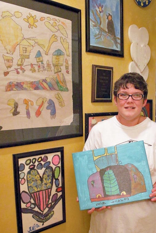 julia holding an art canvas she painted of a truck