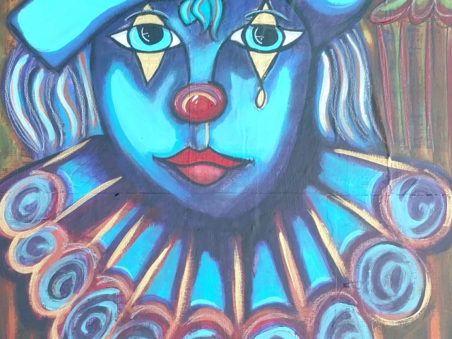 a clown with a blue face and hair
