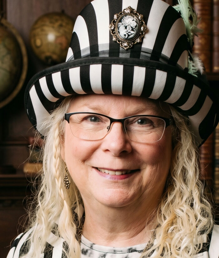 Kimberly is wearing a black and white striped hat with a cameo on the front